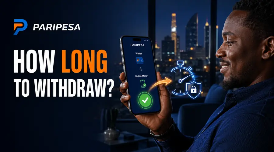 Close-up of a smartphone showing a mobile money withdrawal confirmation glow, dark warm-toned lighting